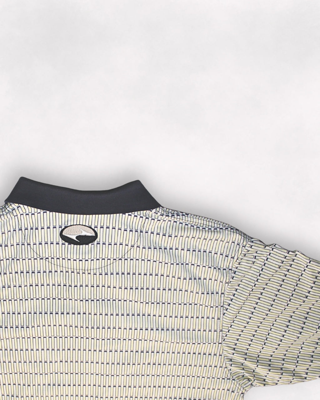 Close-up of a patterned shirt with a logo on a white background